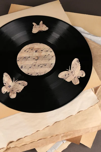 Oude vinyl record met oud papier en vlinders — Stockfoto