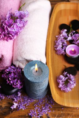 kaplıca tedavisi, ahşap kase su, havlu ve ahşap zemin üzerine Eflatun çiçekler ile kompozisyon