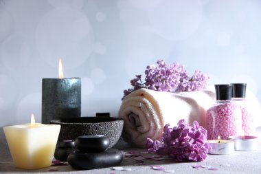 üzerinde açık renkli ahşap masa üzerinde spa tedavisi, havlu ve eflatun çiçekler ile kompozisyon