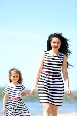 mutlu anne ve kızı. Sahilde yürüyüş