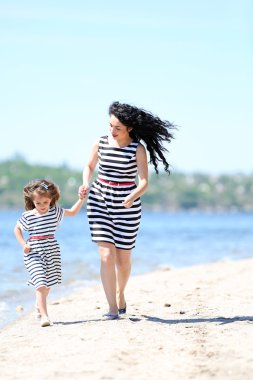 mutlu anne ve kızı. Sahilde yürüyüş