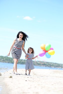 mutlu anne ve kızı. Sahilde yürüyüş