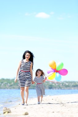 mutlu anne ve kızı. Sahilde yürüyüş