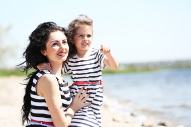 mutlu anne ve kızı. Sahilde yürüyüş