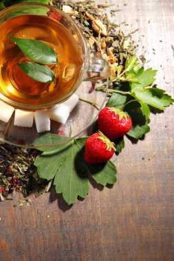 Çay ve cam bardakta, renk ahşap arka plan için kuru çiçekler otlar ve meyveler malzemeler ile kompozisyon