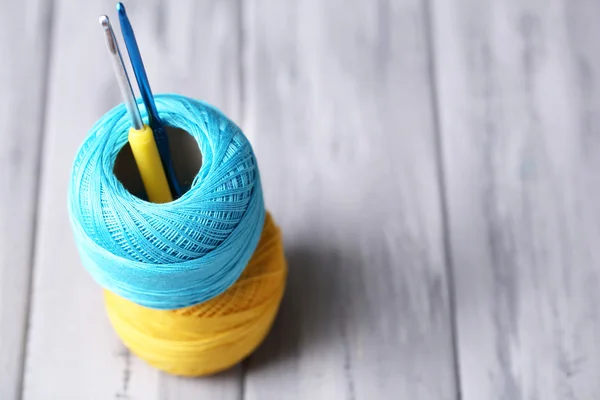 Colorful clews and crochet hook on wooden background — Stock Photo, Image