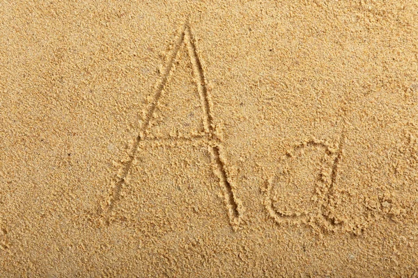 Alfabet brev skrivet på våta beach sand — Stockfoto