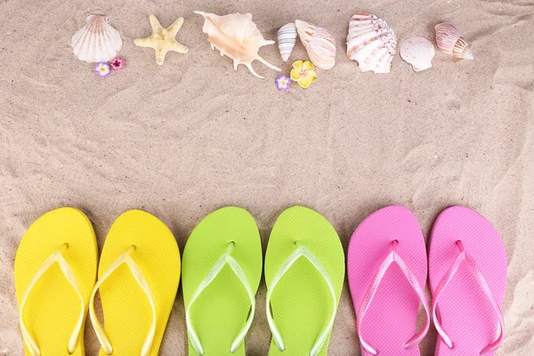 Bright flip-flops on sand, close up — Stock Photo, Image