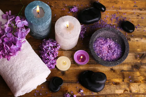 Composição com tratamento de spa, toalhas e flores lilás, sobre fundo de madeira — Fotografia de Stock