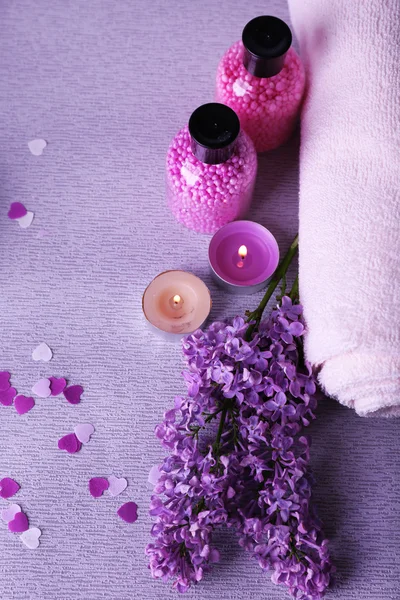 Composition with spa treatment, towels and lilac flowers, on light background — Stock Photo, Image