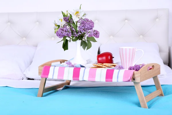 Lehká snídaně a krásnou kytici na posteli — Stock fotografie