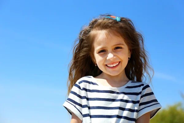 空を背景に小さな女の子の美しい肖像画 — ストック写真