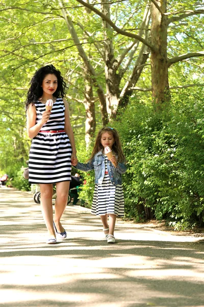 Gelukkig moeder en dochter. wandelen in het groene park — Stockfoto