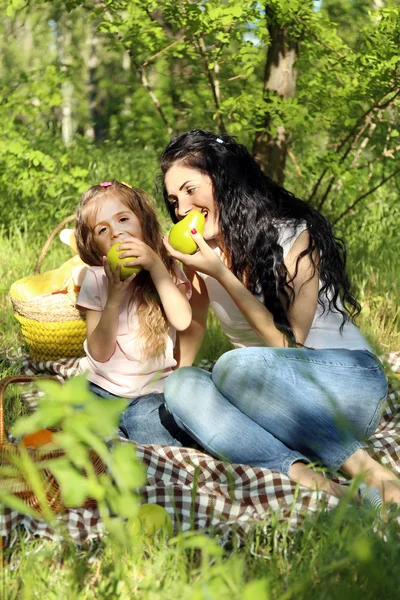 Mãe e filha felizes. Piquenique no parque verde — Fotografia de Stock