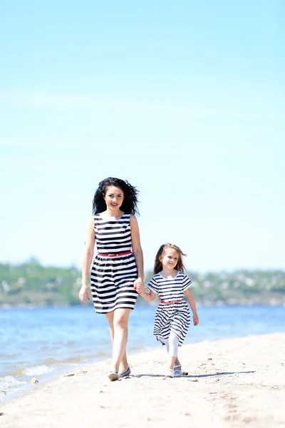 Happy mom and daughter. Walk on the beach — Stock fotografie