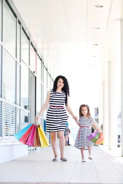 Joyeux maman et fille avec des sacs de magasin, en plein air — Photo