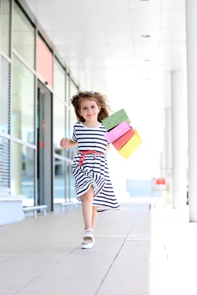 Ευτυχισμένη κοριτσάκι με τσάντες κατάστημα, σε εξωτερικούς χώρους — Φωτογραφία Αρχείου