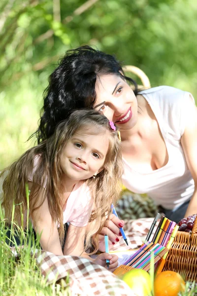 Happy mom and daughter. Picnic in the green park — Stock Photo, Image