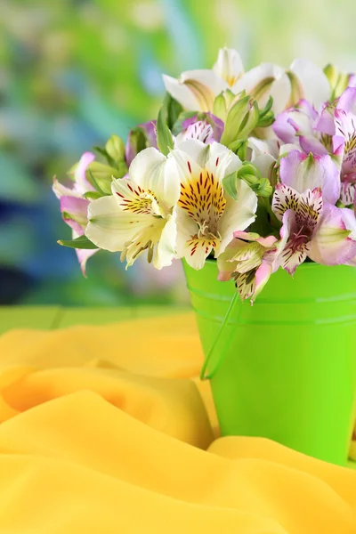 Bouquet of freesias in pail on table on natural background — Stock Photo, Image