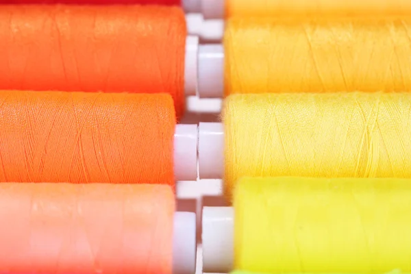 Многоцветные нити для шитья фона — стоковое фото