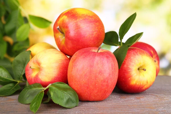 Manzanas dulces maduras con hojas sobre fondo natural —  Fotos de Stock