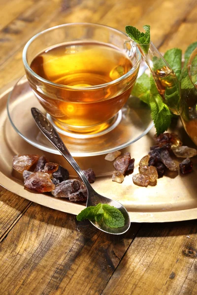 Composition of fresh mint tea in glass cup and teapot on tray, on wooden background — Stock Photo, Image