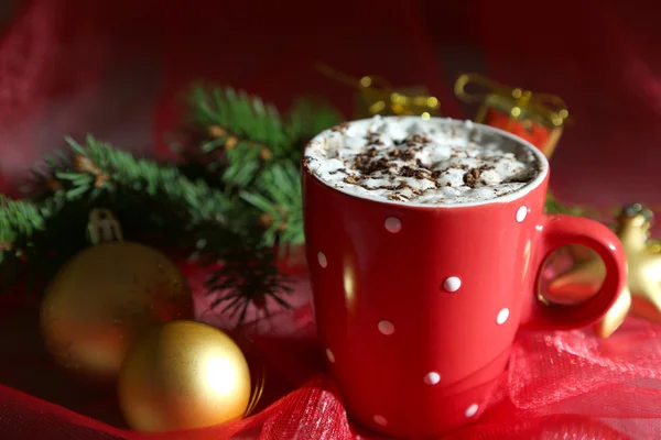 Cioccolata calda con crema in tazza di colore, sul tavolo, su sfondo decorazioni natalizie — Foto Stock