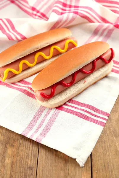 Tasty hot dogs on wooden table — Stock Photo, Image