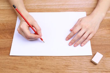 insan eli kalem kağıt ve erase kauçuk ahşap masa arka plan üzerinde yazma ile