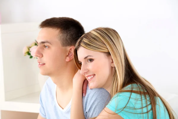 Amante casal sentado no sofá, em casa interior fundo — Fotografia de Stock