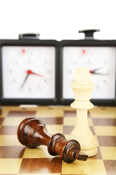 Tablero de ajedrez con ajedrez y reloj, aislado en blanco — Foto de Stock