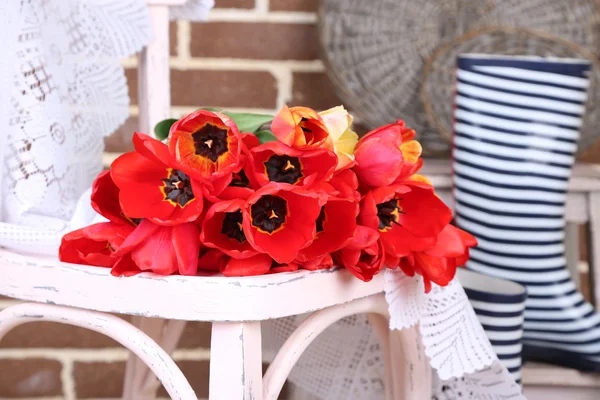 Bouquet di tulipani colorati sulla sedia, su sfondo interno di casa — Foto Stock