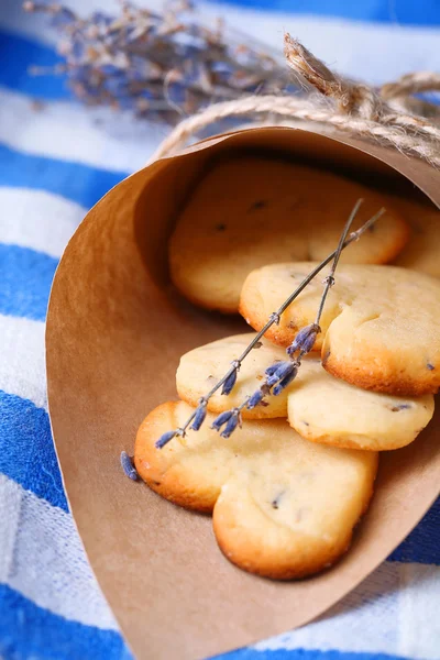 Soubory cookie levandule v papírové tašce, na barevný ubrousek pozadí — Stock fotografie