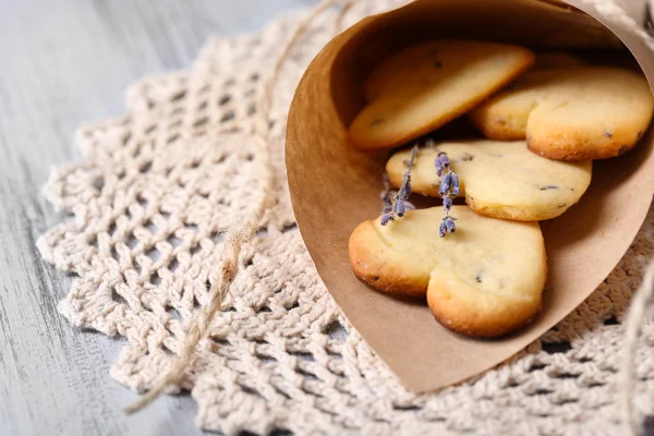 Lavender cookies in paper bag, on color wooden background — Stock Photo, Image