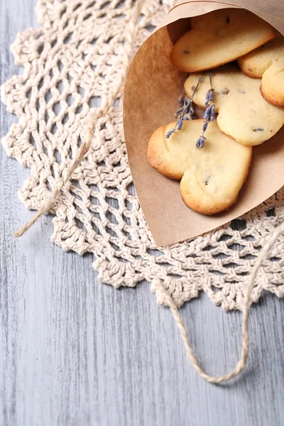 Soubory cookie levandule v papírové tašce, na barevné dřevěné pozadí — Stock fotografie