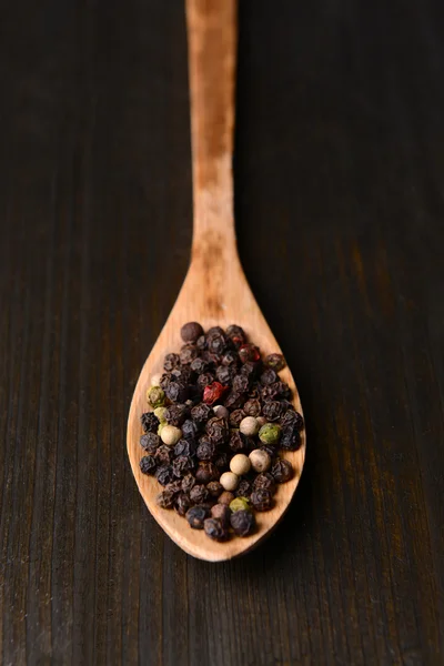 Spice pepper in spoon on wooden background — Stock Photo, Image