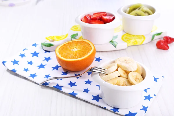 Vários frutos cortados em tigelas na mesa close-up — Fotografia de Stock