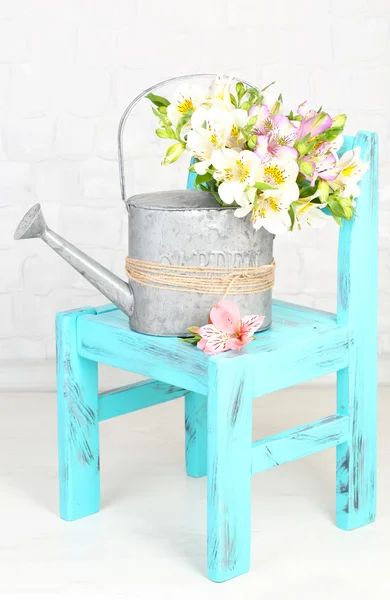 Krásnou kytici frézie v konev na židli v pokoji — Stock fotografie