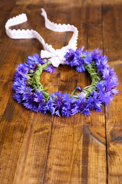 Fresh cornflower wreath on wooden background — Stock Photo, Image