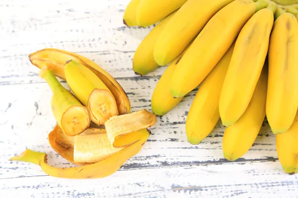 Bunch of mini bananas on color wooden background — Stock Photo, Image