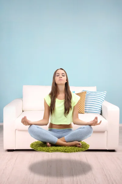 Beautiful girl fly and meditating in yoga pose — Stock Photo, Image