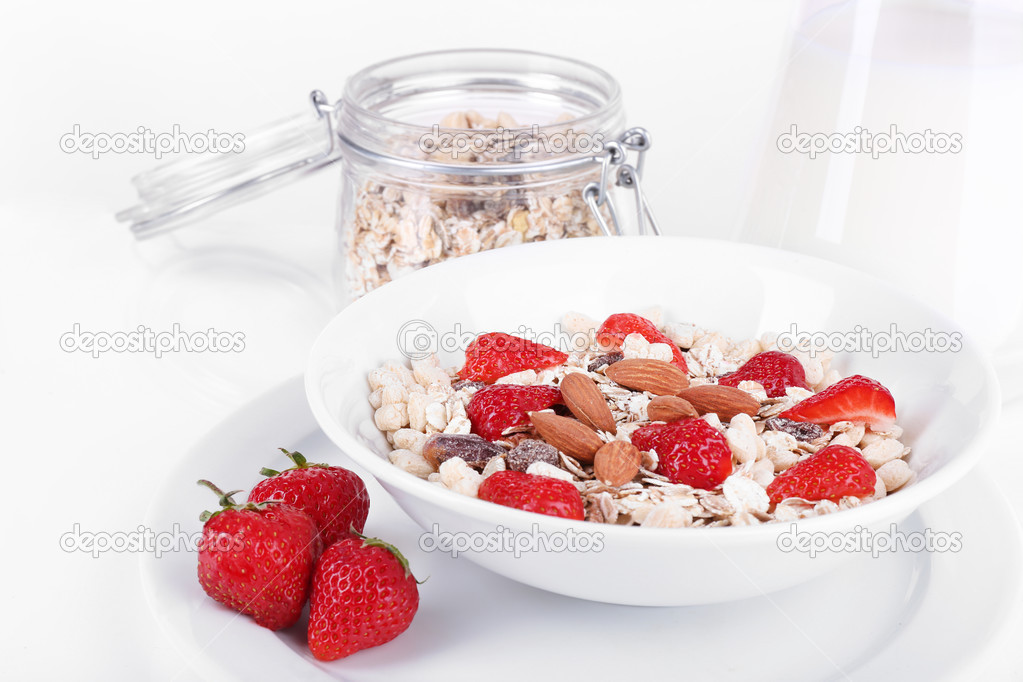 Healthy cereal in bowl with milk and strawberries isolated on white