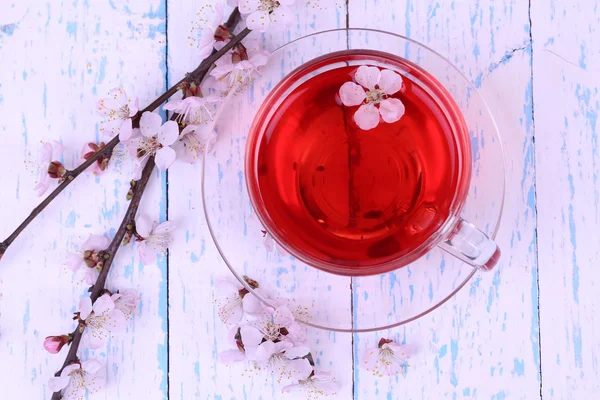 Fragrant tea with flowering branches on wooden table close-up — Stock Photo, Image