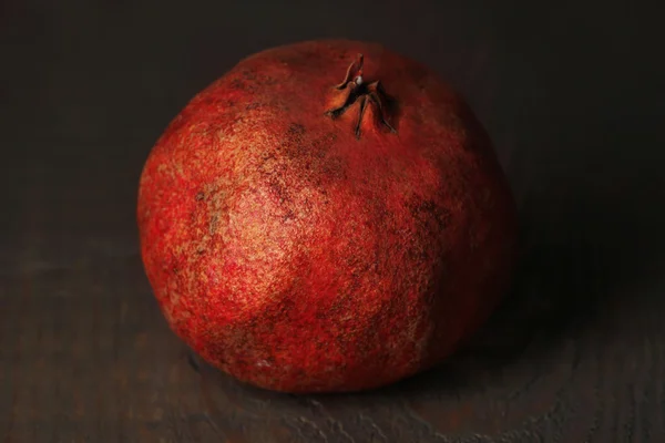 Ripe pomegranate on color wooden background — Stock Photo, Image