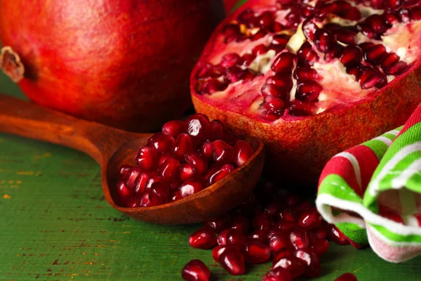 Ripe pomegranates on color wooden background — Stock Photo, Image