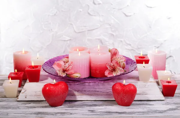 Lindas velas com flores na mesa em fundo cinza — Fotografia de Stock