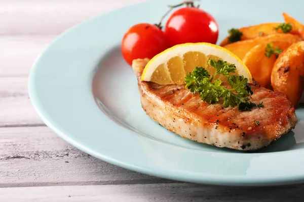 Bife grelhado, legumes grelhados e pedaços de batata frita na mesa, no fundo brilhante — Fotografia de Stock