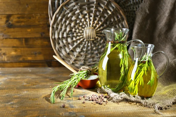 Eterisk olja med rosmarin i glas tillbringare, på trä bakgrund — Stockfoto