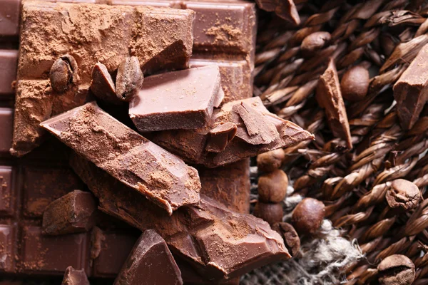 Nasekané balíček čokolády na proutěné rohože pozadí — Stock fotografie