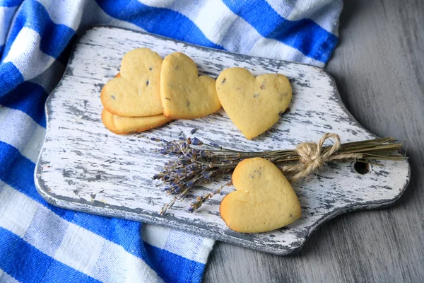 Soubory cookie levandule na prkénko, na barevný ubrousek pozadí — Stock fotografie